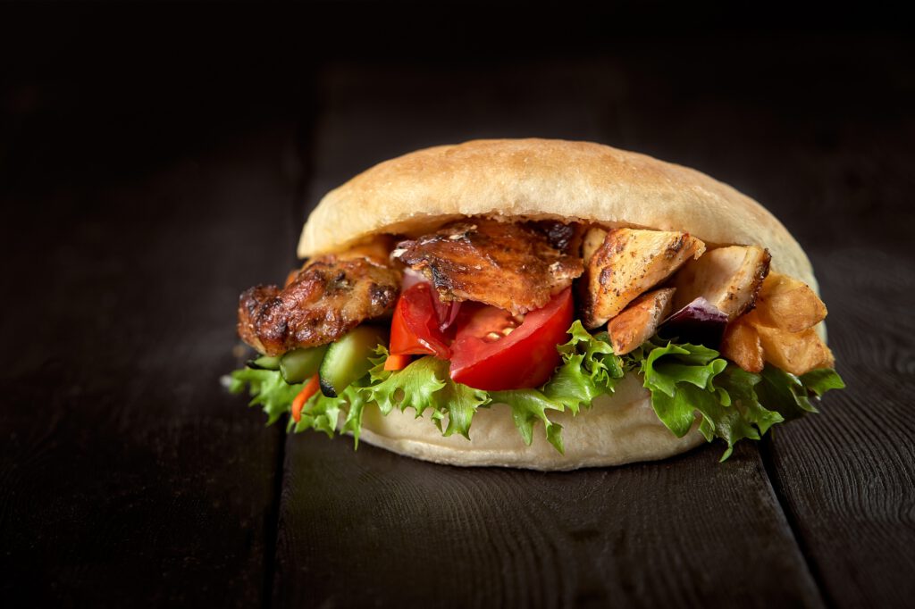 close up of kebab sandwich on wooden background